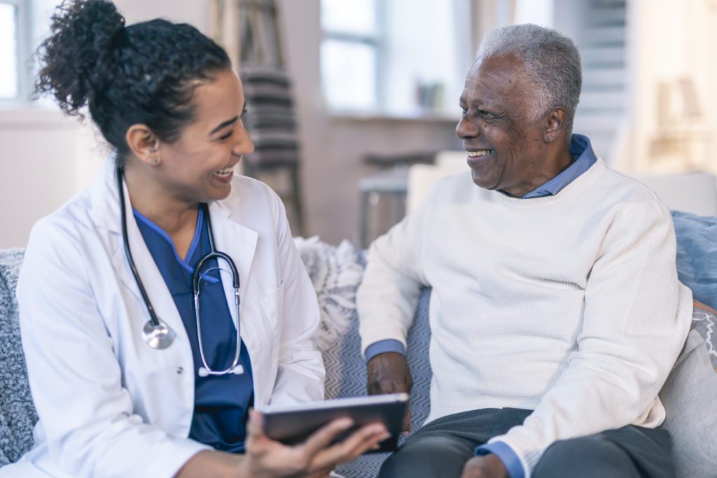 Female healthcare professional meeting with patient in his home