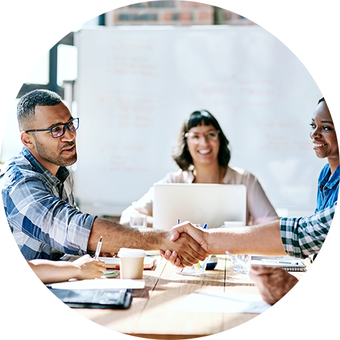 young professionals shaking hands across a conference table