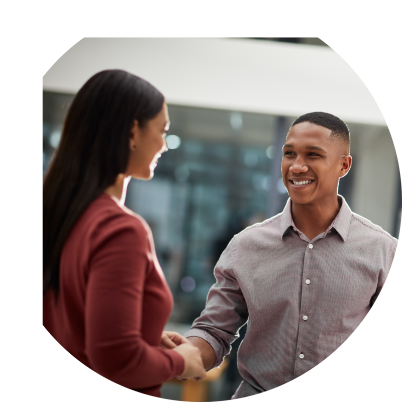 Young man and woman in office setting shaking hands