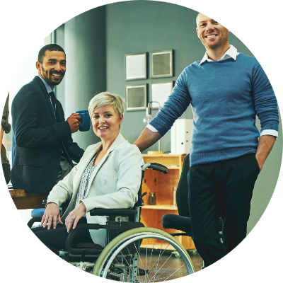 Group of young professionals, one in a wheelchair smiling in an office setting
